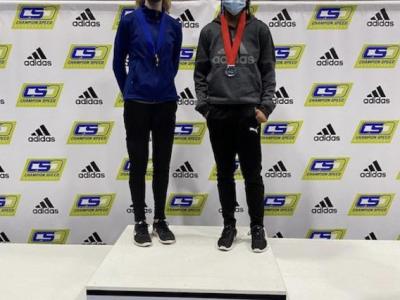 Two female track athletes pose on the podium 