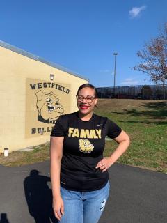 Vanessa hunter standing in front of the stadium, wearing a Bulldog Family tshirt